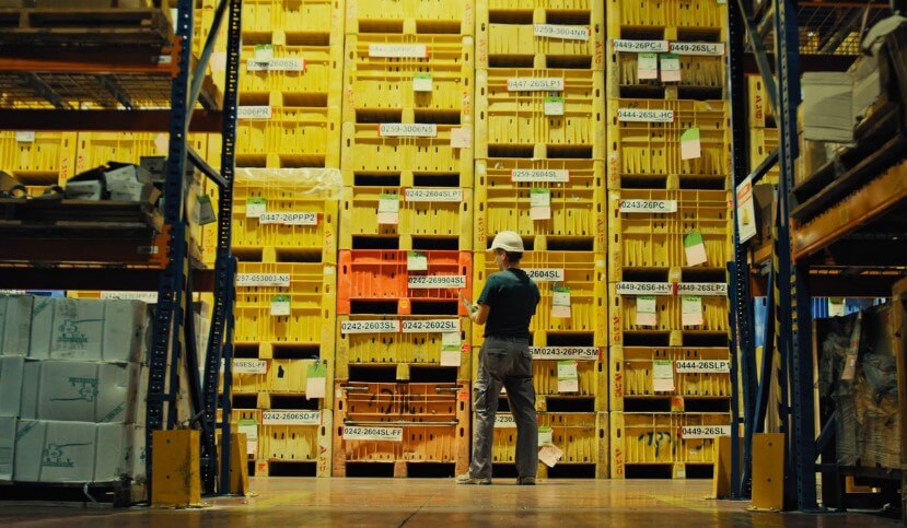 Worker checks inventory in a vast warehouse